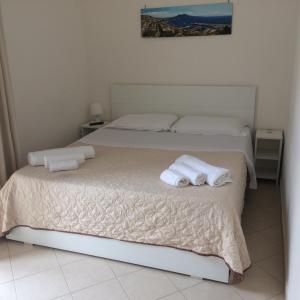 ナポリにあるB&B LA CONIGLIERAのベッドルーム1室(ベッド2台、ベッド上にタオル付)