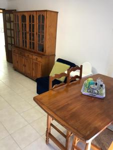 a living room with a wooden table and a chair at Edificio Canoa in Armação de Pêra
