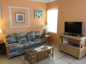 a living room with a couch and a tv at Atlantic Sands Beach Suites in Hollywood