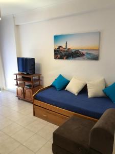 Un dormitorio con una cama, un televisor y un sofá. en Edificio Canoa, en Armação de Pêra