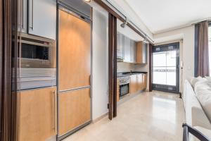 una cocina con electrodomésticos de acero inoxidable y armarios de madera en Travel Hábitat L`Oceanogràfico, en Valencia