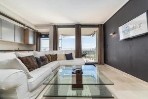 a living room with a white couch and a glass table at Travel Hábitat L`Oceanogràfico in Valencia