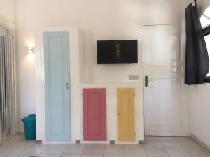 three doors with different colored doors on a wall at Studio Lipstick in Saly Portudal