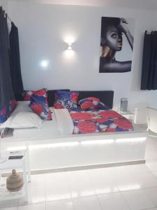 a bedroom with a bed with a black woman on the wall at Studio Lipstick in Saly Portudal