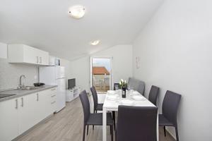 a kitchen and dining room with a table and chairs at Apartments Frado in Novalja