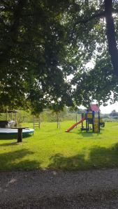 um parque com parque infantil com escorrega em Toscana Restaurant and Bed & Breakfast em Padborg