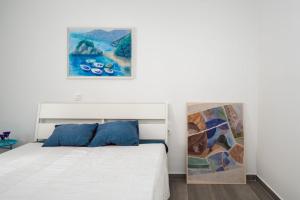 una camera da letto con un letto e un quadro sul muro di Apartment Blue Mediteran a Mlini