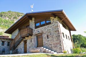 a stone house with a balcony on the side of it at Agriturismo Ruc del Lac in Boario Terme
