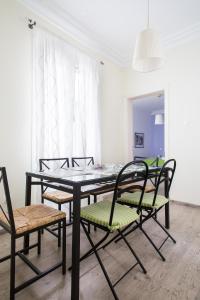 een eetkamer met een tafel en vier stoelen bij Apartments Historical Center in Athene
