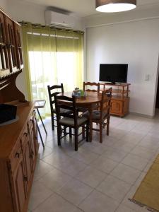 een keuken met een tafel en stoelen en een televisie bij Edificio Nau in Armação de Pêra