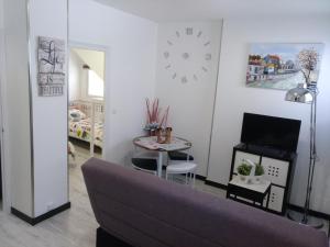 a living room with a couch and a table and a clock at Apartamento Cigüeña 1 in Zaragoza