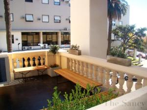 a balcony with a wooden bench and a building at The Sancy in Rosario