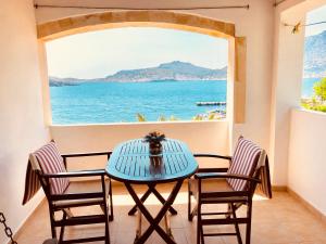 a table with chairs and a view of the ocean at Patras Apartments in Fournoi