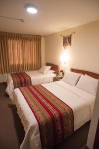 A bed or beds in a room at Hotel Prisma Cusco
