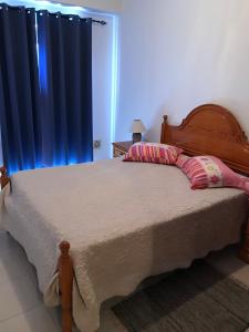 アルマカオ・デ・ペラにあるCaravela Bのベッドルーム1室(大型ベッド1台、木製ヘッドボード付)