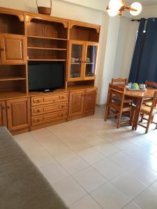 a living room with a tv and a table at Caravela B in Armação de Pêra