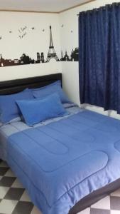 a bedroom with a blue bed with the eiffel tower at La Casa De Huespedes in Bogotá