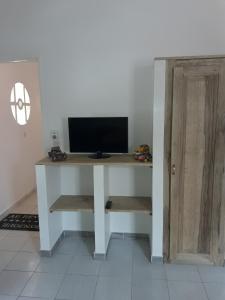 a computer desk with a tv on top of it at Studio Samba in Saly Portudal