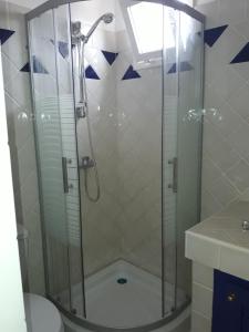a shower with a glass door in a bathroom at Studio Samba in Saly Portudal