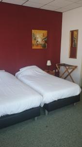 
Een bed of bedden in een kamer bij Hotel het Gemeentehuis Uithuizen
