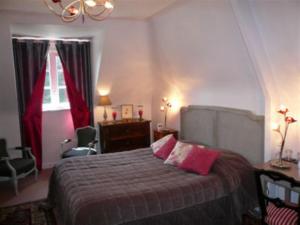 a bedroom with a bed with pink pillows on it at Le Clos du Pont Martin in Saint-Briac-sur-Mer