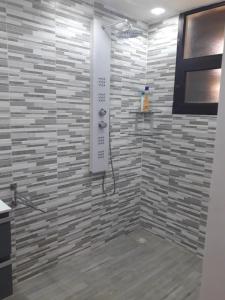 a bathroom with a shower with a stone wall at Studio Sunshine in Saly Portudal