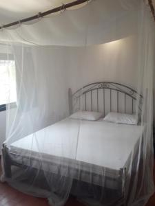 a white bed with a canopy in a room at Studio Sunshine in Saly Portudal