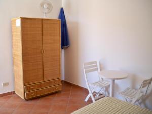 una camera da letto con armadio e tavolo con sedie di L'Isolana Case Vacanza Luna 2 a Ponza