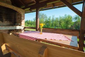 a table with a vase of flowers sitting on a deck at Apartment Ante in Slunj