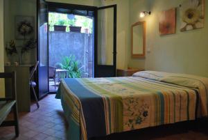 a bedroom with a bed and a door to a yard at Case Vacanze Fossanave in Santa Tecla