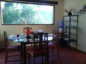 a dining room with a table and chairs and a window at Aconchego das Montanhas in Alagoa