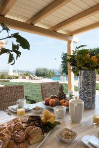 una mesa con pan y otros alimentos. en Villa Emerald, en Porto Heli