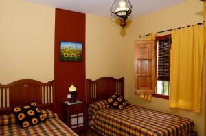 a bedroom with two beds and a window at Casa de la Higuera in Priego de Córdoba +23 photos