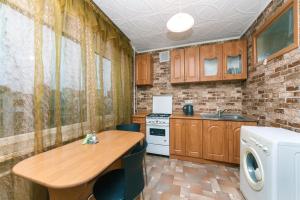 uma pequena cozinha com uma mesa de madeira e um fogão em Уютная однокомнатная квартира возле м.Печерская em Kiev