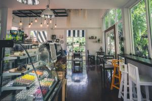 a restaurant with a counter and a room with windows at Hug Inn Phrae in Phrae
