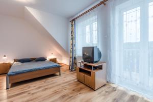 a bedroom with a bed and a tv on a table at Willa Hetman in Karwia