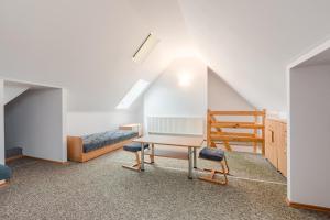 a room with a desk and chairs and a bed at Willa Hetman in Karwia