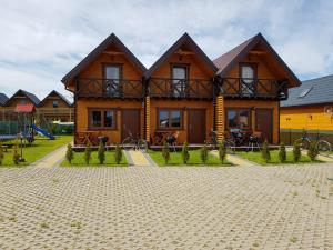 ein großes Holzhaus mit einem Spielplatz davor in der Unterkunft domki letniskowe "U EWKI" in Sarbinowo