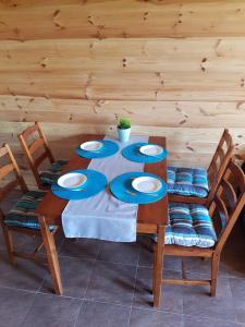 a wooden table with four blue plates on it at domki letniskowe "U EWKI" in Sarbinowo