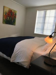 a bedroom with a bed and a table with a lamp at Ellingsens Apartment Egersund in Egersund