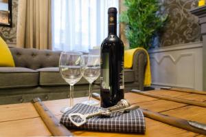 a bottle of wine and two glasses on a table at Viktoria Luxury Apartment in Budapest