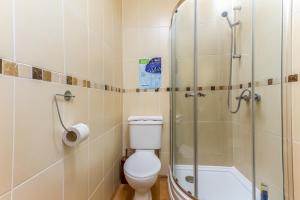 a bathroom with a toilet and a glass shower at Brecks Hotel in Blackpool