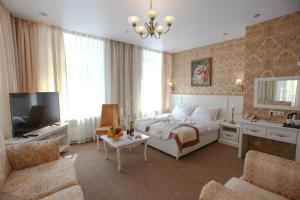 a bedroom with a bed and a tv and a couch at Tchaikovsky Hotel in Moscow