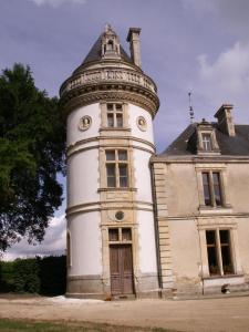 un vecchio edificio con una torre sopra di Château de la Court d'Aron a Saint-Cyr-en-Talmondais