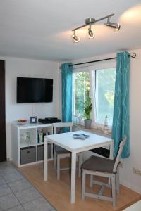 a living room with a white table and a television at Lutzi´s Ferienwohnung in Rostock