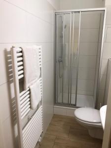 ダルムシュタットにあるHotel KMのシャワーとトイレ付きの白いバスルーム