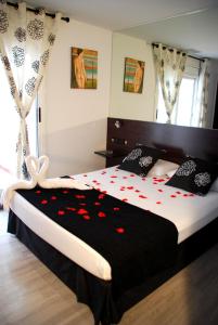 バルセロナにあるHotel Casita Amarillaのベッドルーム1室(赤い花の大きなベッド1台付)