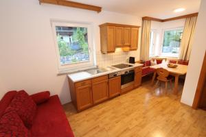 a small kitchen with a red couch and a table at Appartement Hänsel & Gretel in Werfenweng