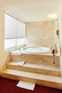 La salle de bains est pourvue d'une baignoire et d'une fenêtre. dans l'établissement Hotel Carrera, à Lima