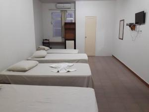 - une chambre avec 4 lits et une serviette dans l'établissement Hotel Danubio, à Itabaiana